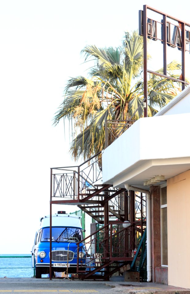 Blue Vehicle Park Near Brown Metal Outdoor Stairs And White Concrete House At Daytime photo