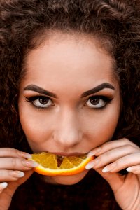 Close-Up Photography Of A Woman Eating Orange photo