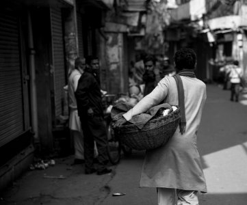 Grayscale Photo Of Woman Carrying Basket photo