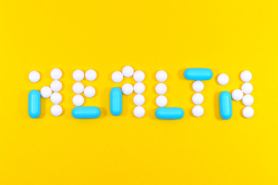 White And Blue Health Pill And Tablet Letter Cutout On Yellow Surface