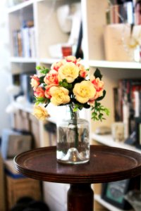 Arrange Of Petal Flower In Clear Glass Vase At Table photo