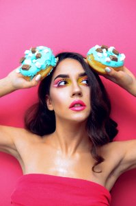 Woman In Red Tube Top Holding Two Doughnuts