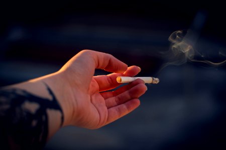 Close-Up Photography Of A Person Holding Cigarette photo