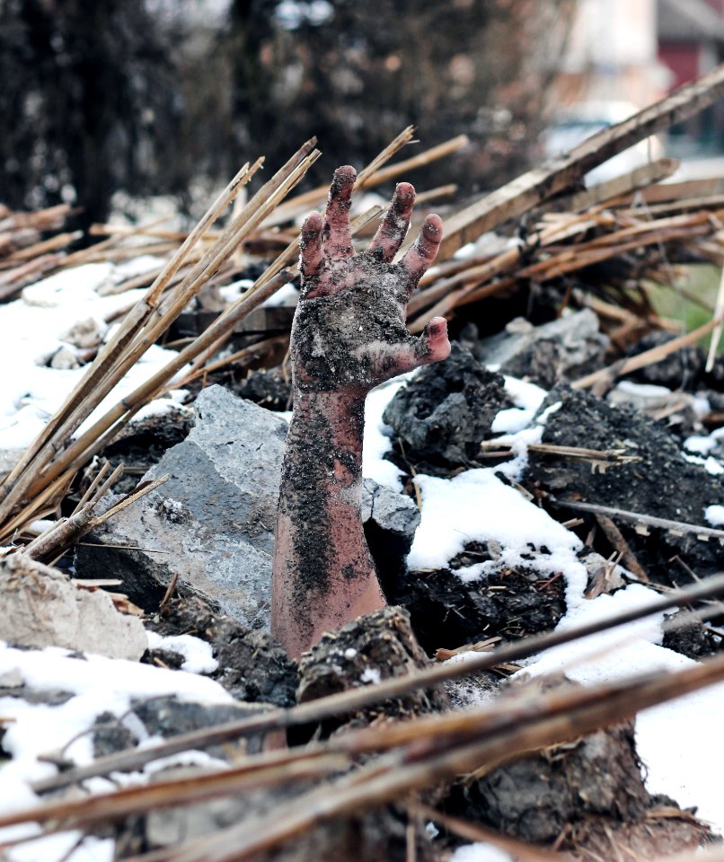Person Buried Under Grey Stone And Black Soils
