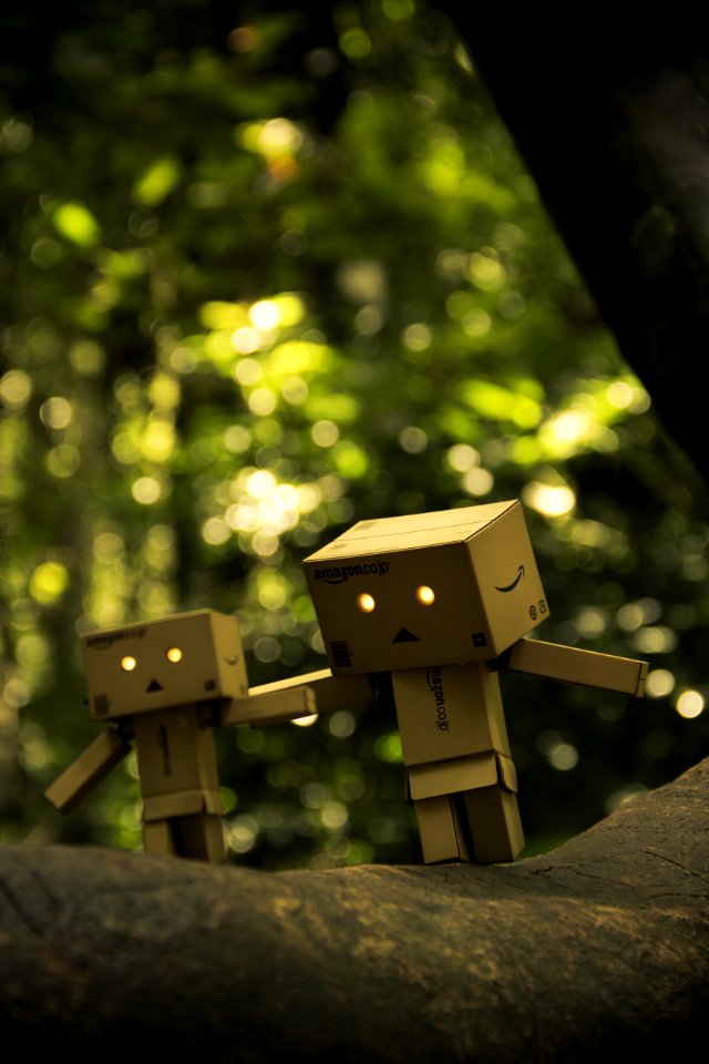 Three Brown Cardboard Box Figures On Brown Surface