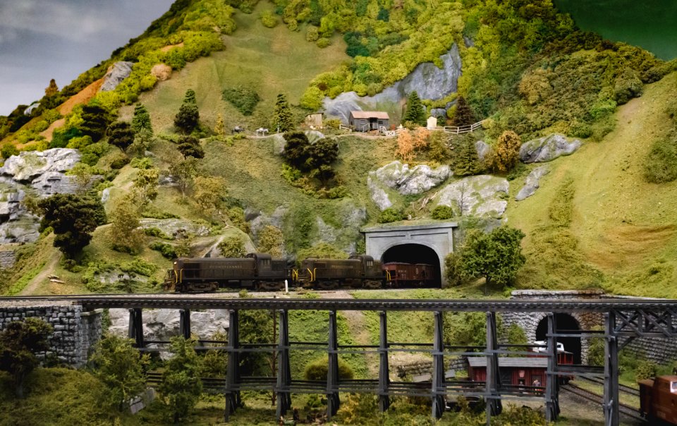 Green And Grey Mountains With Train Trail Going Inside