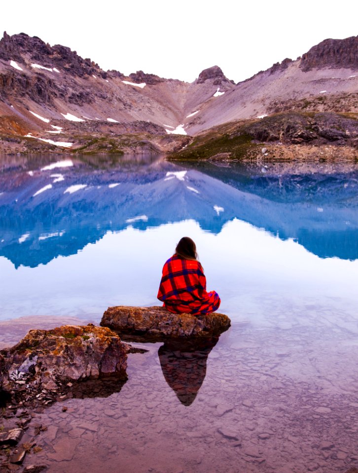 Person Sitting On Rock By The Lake