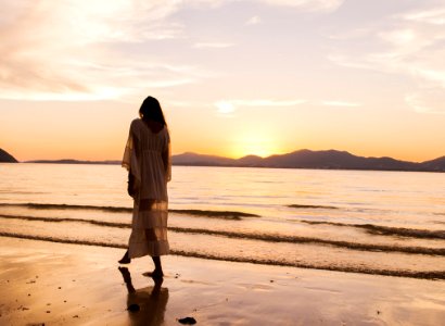 Woman IIn White Dress Walking On Beach