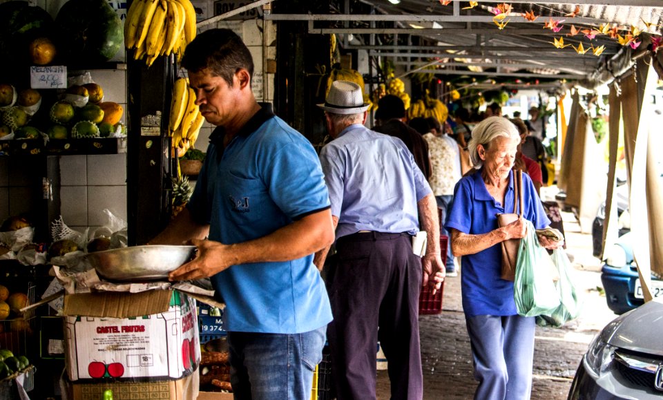 Man Wears Blue Polo Shirt Holding Gray Metal Bowl Near Assorted Fruits photo