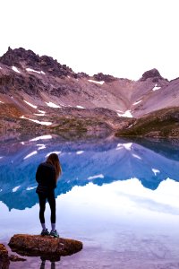 Woman Standing On Rock By The Lake And Mountain photo