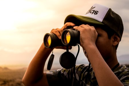 Man Looking In Binoculars During Sunset photo