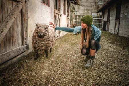 Woman Holding Sheep Beside Wall photo