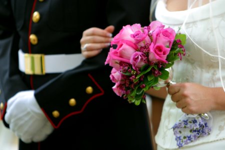 Woman Holding Pink Rose Wedding Bouquet Wearing White Wedding Dress photo