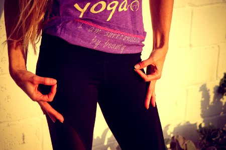 Woman Wearing Purple And White Yoga Printed Shirt And Black Bottoms