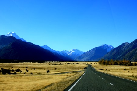 Empty Road Near Mountain Under Blue Skies photo