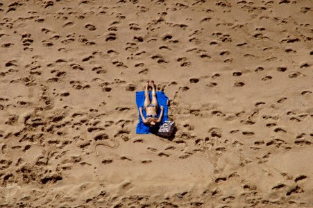 Woman In Blue 2-piece Set Lying On Blue Blanket At Beach On Aerial Photo photo