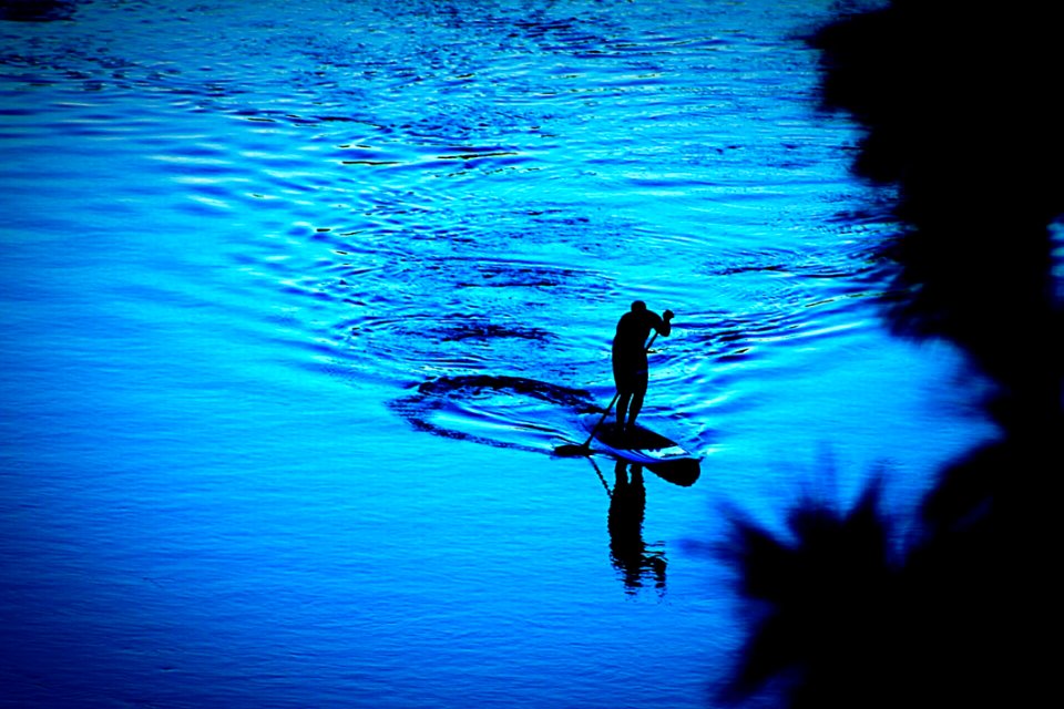 Silhouette Of Person Paddling Boat