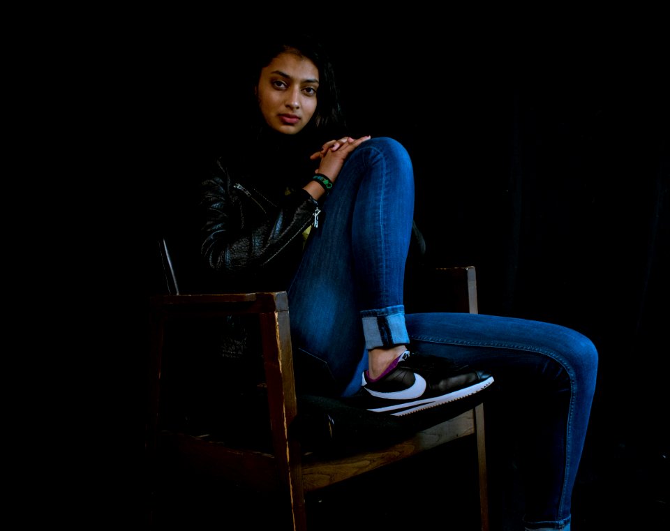 Woman Wearing Blue Jeans Sitting On Brown Wooden Armchair