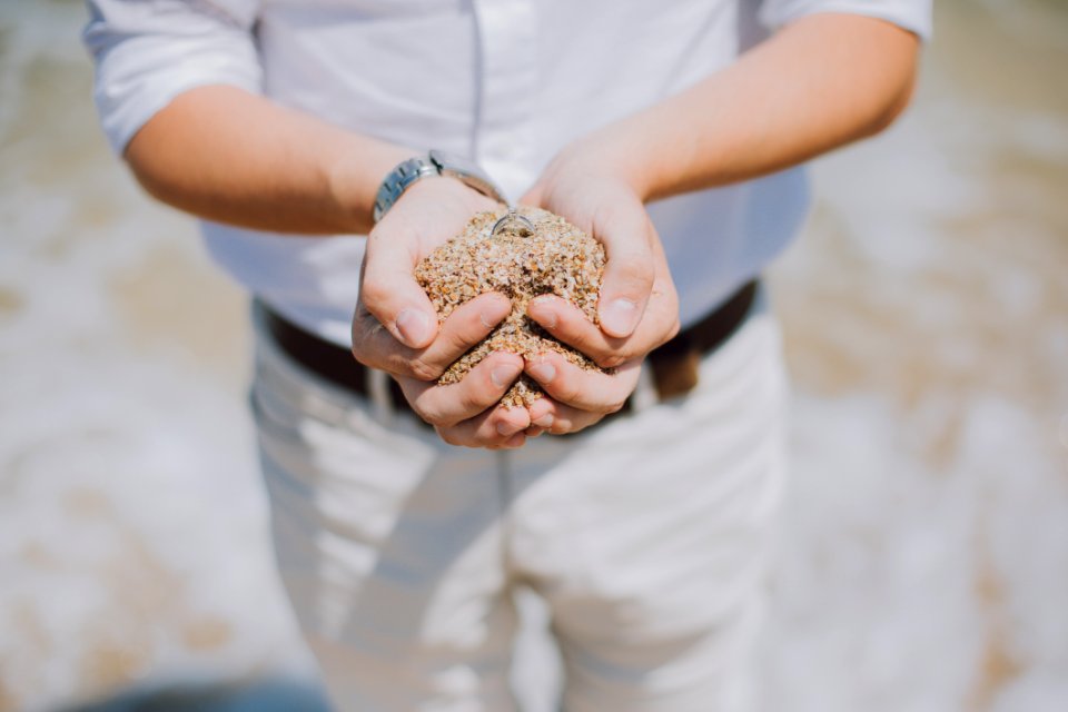 Shallow Focus Photography Of Person Holding Brown Sand photo