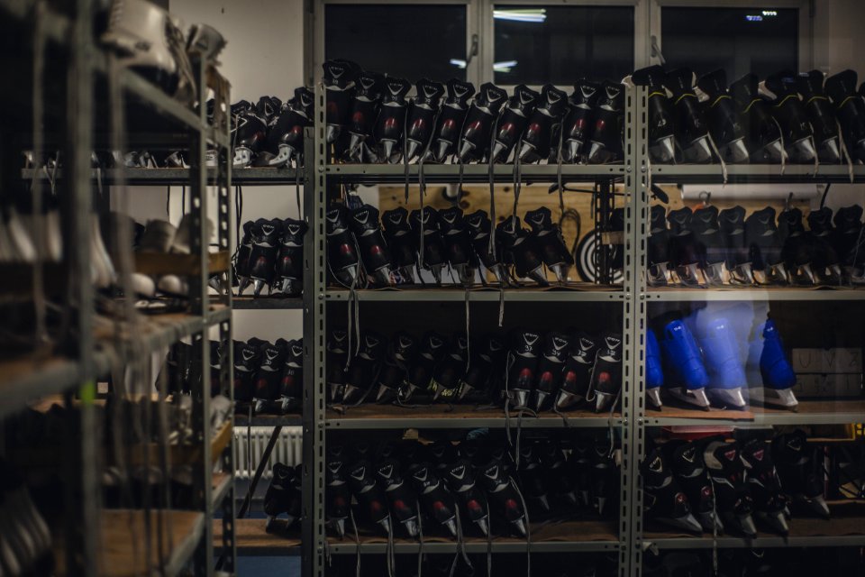 Black And Blue Ice Skates On Gray Metal Shelf Inside White Room