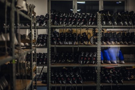 Black And Blue Ice Skates On Gray Metal Shelf Inside White Room