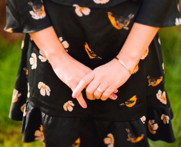 Close Up Photo Of Person Wearing Black And Orange Floral Dress photo