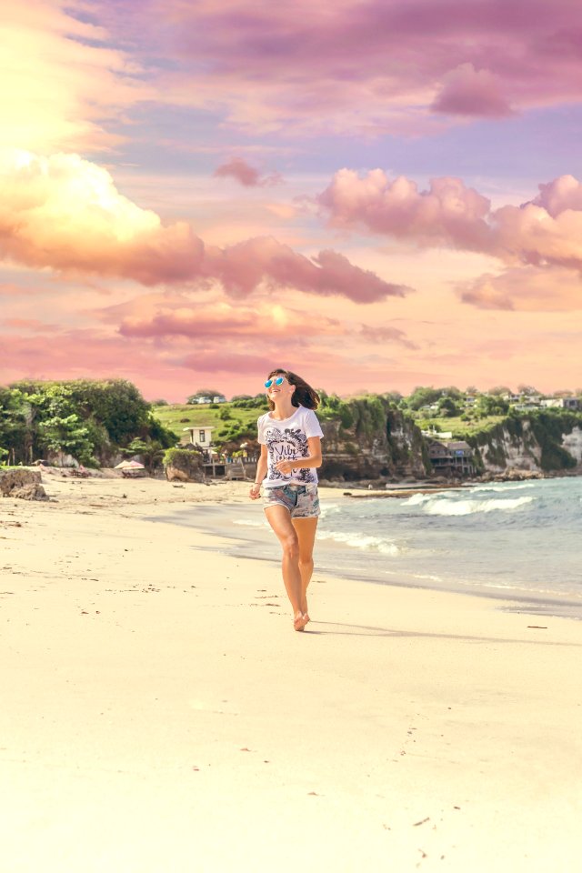 Smiling Woman Walking Barefood On Seashore Near Houses