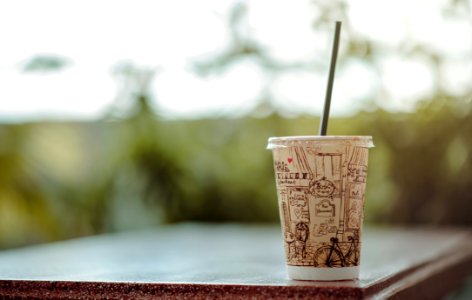 Selective Focus Photo Of White Plastic Cup With Lid And Straw photo