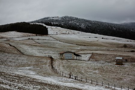 Brown Wooden House Surrounded With Brown Field Near Mountain Under Gray Sky At Daytime photo