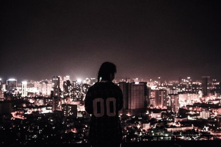 Photo Of A Person Watching Over City Lights During Night Time