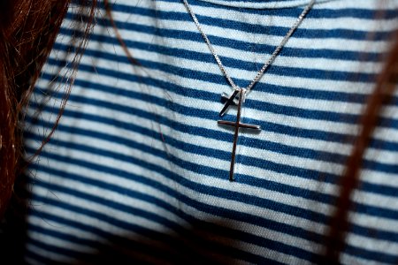 Silver-colored Cross Pendant On Black And White Stripe Textile