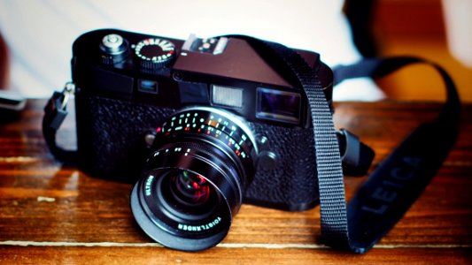 Black Dslr Camera On Top Of Brown Wooden Table