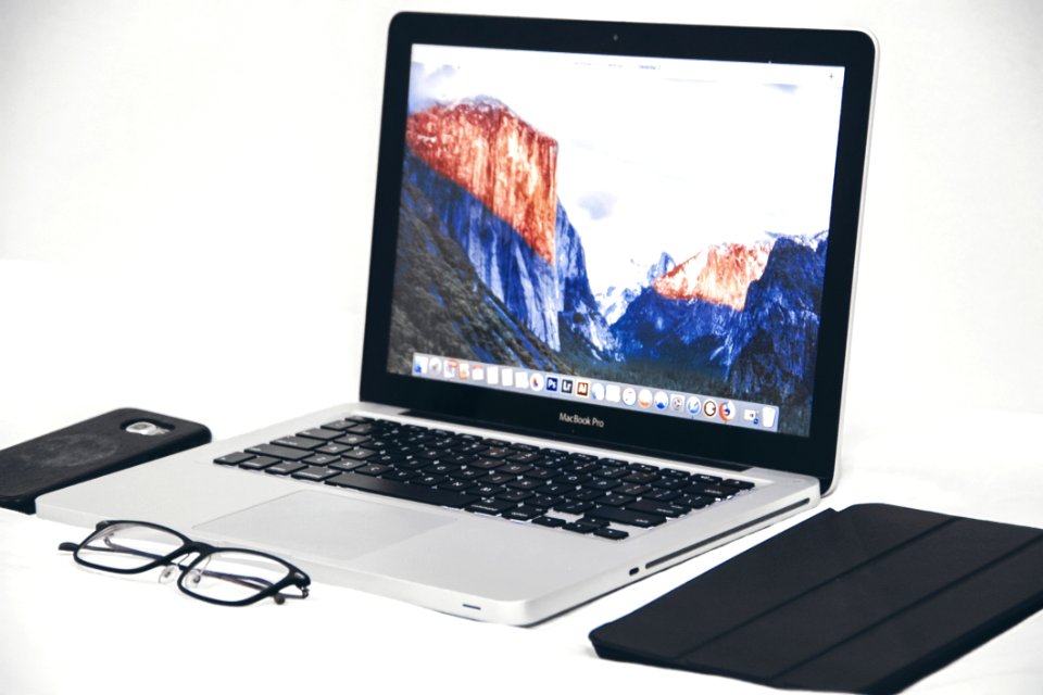 Macbook Air Beside Eyeglasses And Black Smart Case
