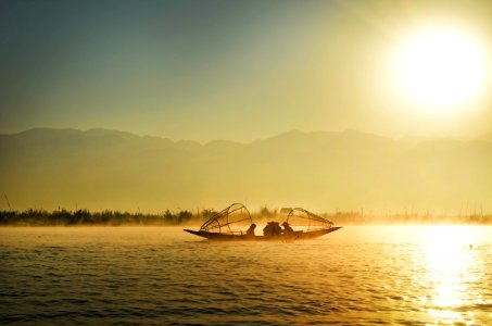 Group Of People Riding Boat In The Middle Of Water During Sunrise photo