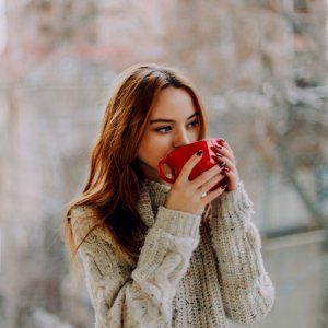 Selective Focus Photography Of Woman Holding Red Ceramic Cup photo