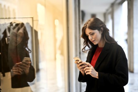 Close-up Photo Of Woman In Black Coat Using Smartphone photo