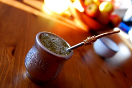 Silver-colored Teacup With Stirrer On Brown Wooden Table photo