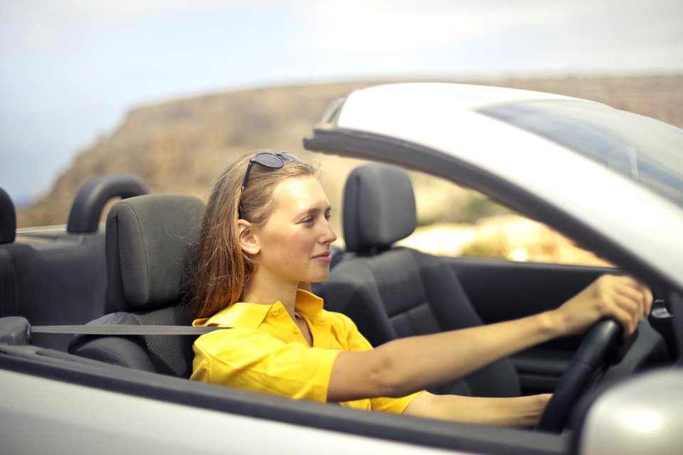 Woman In Yellow Shirt Driving A Silver Car
