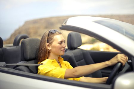 Woman In Yellow Shirt Driving A Silver Car photo