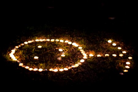 Arrow Shaped Lighted Tealight Candles On Grass photo