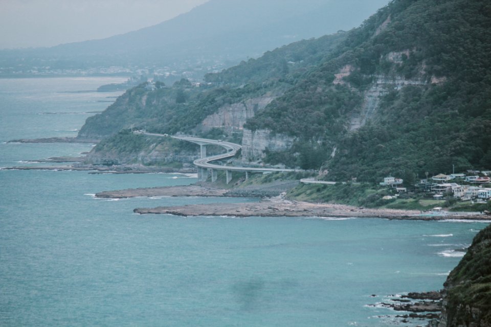 Green Island With Curved Bridge Near Body Of Water