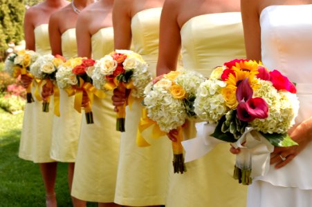 Women Wears White And Yellow Tube Strapless Dresses Holding White Red And Yellow Bouquet photo