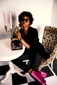 Photo Of Woman Wearing Black Long-sleeved Tunic And Pinstriped Pants Sitting On Sofa Chair