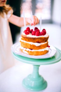 Girl Putting A Candle On 3-layered Cake