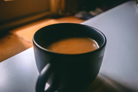 Shallow Focus Photography Of Black Ceramic Mug Filled With Brown Coffee On The Table photo