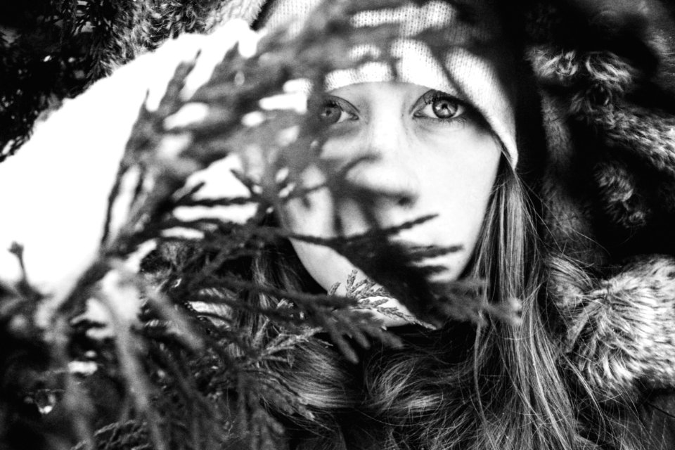 Grayscale Photo Of Woman Behind Leaves