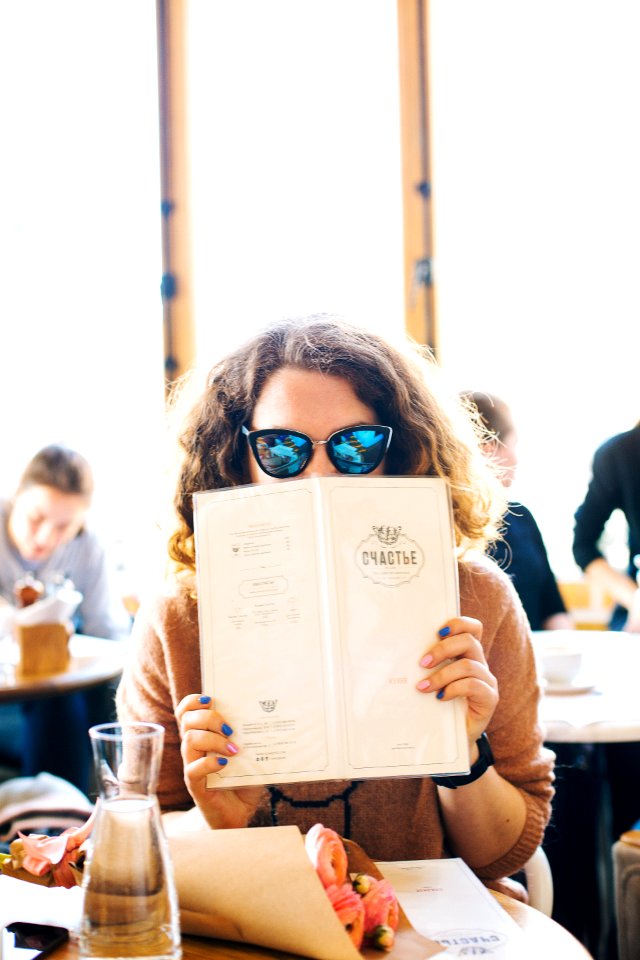 Woman In Black Sunglasses Holding Menu