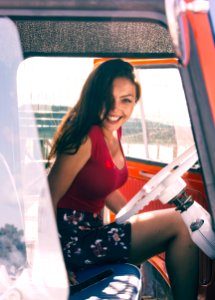 Woman In Red Shirt Sitting On Vehicle Seat At Daytime