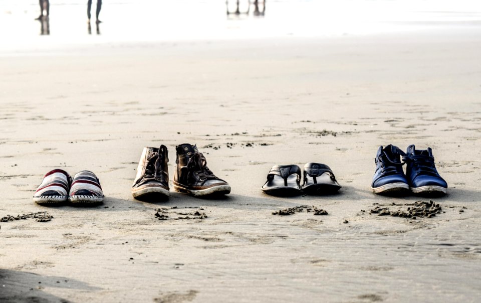 Photo Of Assorted Pairs Of Footwear On Sand