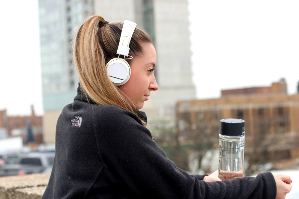 Woman Wearing Black Jacket With White Headphones
